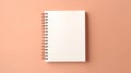 A blank notebook on a peach colored surface, peach fuzz, trendy color of the year 2024.