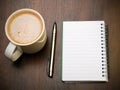 Blank notebook, pen and cup of coffee on wooden brown background, Royalty Free Stock Photo