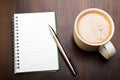 Blank notebook, pen and cup of coffee on wooden brown background Royalty Free Stock Photo