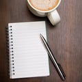 Blank notebook, pen and cup of coffee on wooden brown background Royalty Free Stock Photo