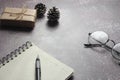 Blank Notebook, Pen, Glasses and small gift boxes placed on a gray table Royalty Free Stock Photo