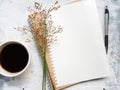 Blank notebook with pen next to a cup of coffee.