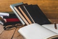 Blank notebook with pencil, glasses and books on wooden table. Royalty Free Stock Photo