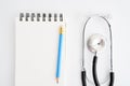 Blank notebook with pencil put on white desk with stethoscope. U