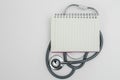 Blank notebook on stethoscope white background. heart and healthcare concept. diagnostic, disease, cardiology. equipment research