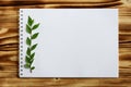 Blank notebook for text with a green branch on a wooden background, top view Royalty Free Stock Photo