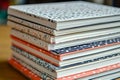 Blank notebooks with various vibrant patterns are arranged in a neat stack on a wooden table, showcasing their colorful Royalty Free Stock Photo