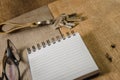 Blank notepad, key chain and eye glasses on wooden table