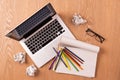 Blank notepad, laptop and pencils with sheets of crumpled paper