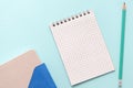 Blank notepad, organizer and pencil on turquoise background