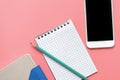 Blank notepad, organizer, phone and pencil on pink background