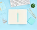 Blank notepad page for text on blue office desktop. Top view of modern bright table with notebook, keyboard. Mock up, copy space Royalty Free Stock Photo