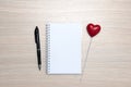 Blank notepad, pencil and red heart on wooden table Royalty Free Stock Photo