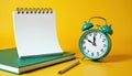 Blank notepad sits next to alarm clock and green diary on yellow surface. Time to make plans or schedule important events. Royalty Free Stock Photo