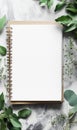 Blank spiral notepad surrounded by green leaves on a textured surface suitable for notes or creative writing. Generative Royalty Free Stock Photo