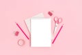 Blank notepad template with stationery on a pink pastel background