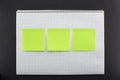 Blank notepad with three empty green sticky notes on black background Royalty Free Stock Photo