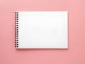 Blank notepad white page on pink desk, color background. Top vie