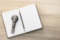 Blank notepad wrist watch with a pencil on an office table. Blank open notebook and wristwatch with metal bracelet Royalty Free Stock Photo