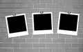 Blank old photos on clips on brick wall Royalty Free Stock Photo