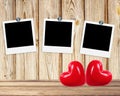 Blank old photos on clips and red hearts on wooden background Royalty Free Stock Photo
