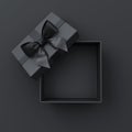 Blank open black present box or top view of black gift box with black ribbons and bow on dark background with shadow