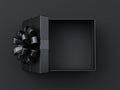 Blank open black present box or top view of opened black gift box with black ribbons and bow on dark background with