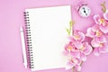 The blank open notebook and clock with pink color orchid for your text or message Royalty Free Stock Photo