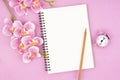 The blank open notebook and clock with pink color orchid for your text or message Royalty Free Stock Photo