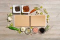 Blank open notebook for notes and pepper, bay leaf, rosemary, onions, Himalayan salt, olive oil, soy sauce on a w Royalty Free Stock Photo