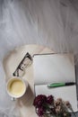 Blank open notebook, pair of glasses, cup of coffee and flowers. Royalty Free Stock Photo