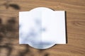 Blank opened bifold card on a classic empty white plate on the outdoor wooden table top view background as template for you design Royalty Free Stock Photo