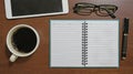 Blank opened notebook for input the text, With pen, glasses, coffee cup and tablet on wooden table, Flat lay table top view Royalty Free Stock Photo