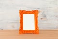 Blank orange photo frame over wooden table and white background. Ready for photography montage Royalty Free Stock Photo