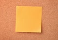 Blank orange sticky note on cork board Royalty Free Stock Photo