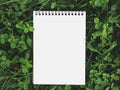 Blank page of the Notebook lying on a clover