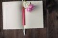 blank page of notebook and pencil ,pink flower on wood background Royalty Free Stock Photo