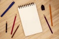 Blank page of sketch pad, pencil and pen on wooden table top view. Summer travel journal or art book banner background Royalty Free Stock Photo