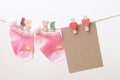 Blank paper with baby socks hanging on love clothesline Royalty Free Stock Photo