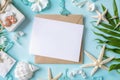 Blank paper on blue pastel background with shells and starfish, empty note for holidays on beach Royalty Free Stock Photo