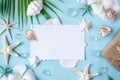 Blank paper on blue pastel background with shells and starfish, empty note for holidays on beach Royalty Free Stock Photo