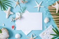 Blank paper on blue pastel background with shells and starfish, empty note for holidays on beach Royalty Free Stock Photo