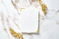 Blank paper card with golden floral branches on marble table. Wedding invitation mockup, birthday greeting card design Royalty Free Stock Photo