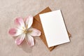 Blank paper card with mockup copy space, envelope and flowers on neutral beige background, aesthetic wedding invitation or