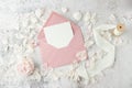 Blank paper card and open retro pink envelope with peony flower and petals on white grunge stone background Royalty Free Stock Photo