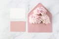 Blank paper cards and open retro pink envelope with peony flowers on white marble background. Invitation floral card in vintage Royalty Free Stock Photo