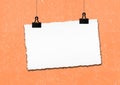 Blank paper frame hanged by clip on grunge wall background