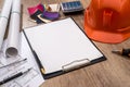 house plan, helmet and work tolls on desk