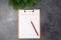 Blank paper with new year`s resolutions title and red pencil on grey table. Flat lay. Top view. New year concept. Target Royalty Free Stock Photo