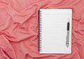 Blank paper notebook with pen on beautiful pastel silk background. Royalty Free Stock Photo